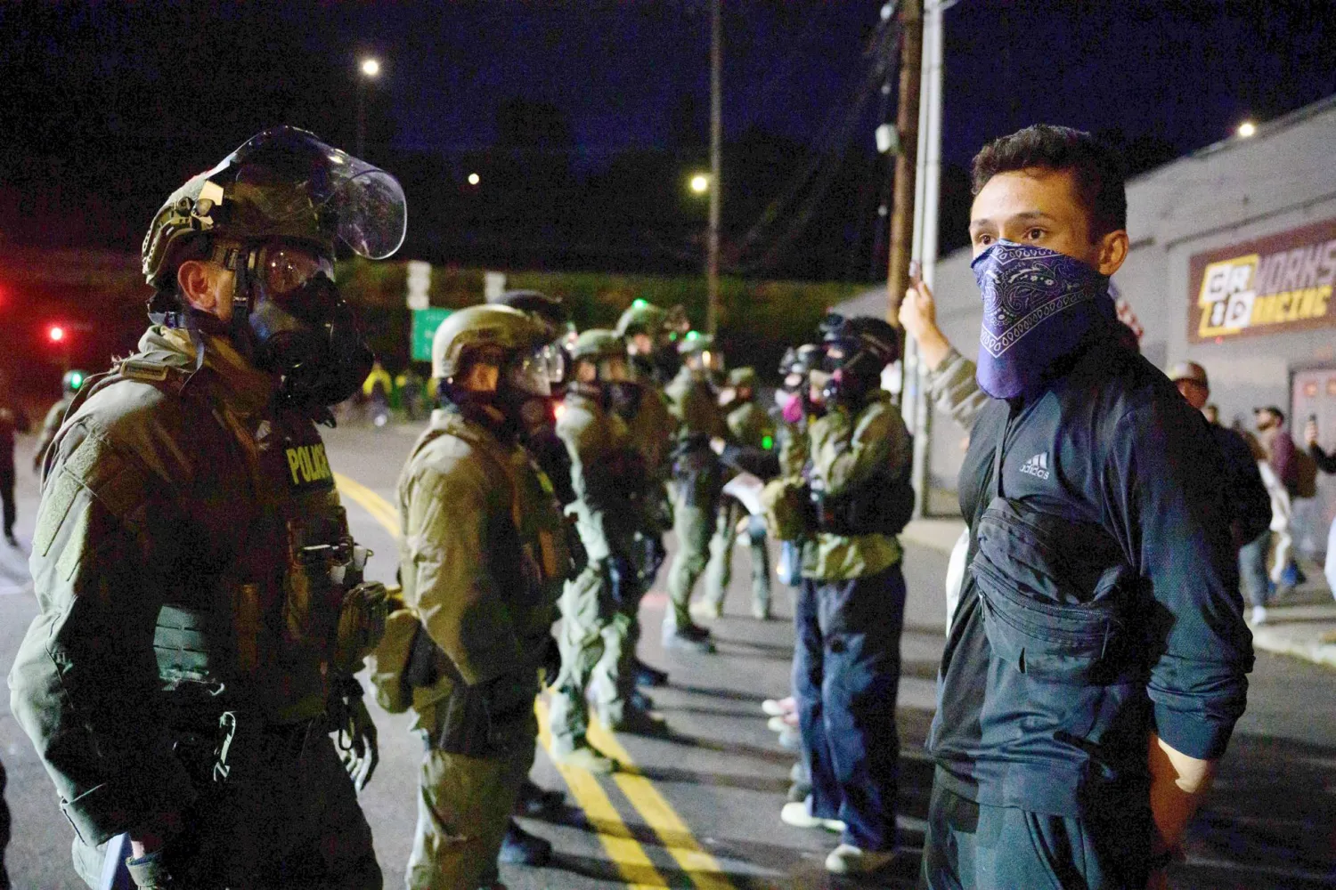 Federal agents stand guard to keep demonstrators away from an Immigration and Customs Enforcement (ICE) facility in downtown Portland, Oregon, on October 6, 2025. (Photo by Mathieu Lewis-Rolland / AFP)