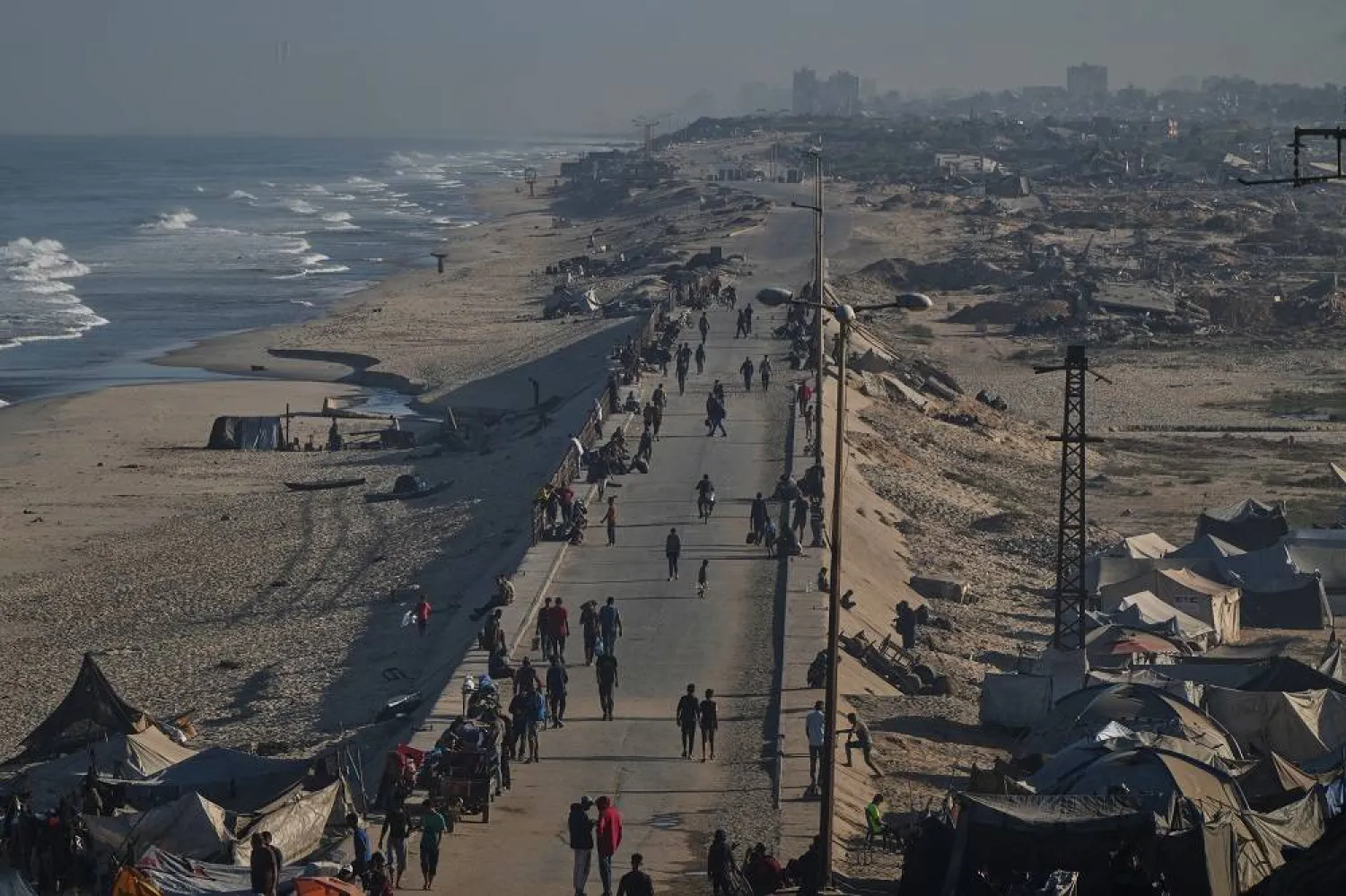 Displaced Palestinians walk along the coastal road near Wadi Gaza in the central Gaza Strip, Friday, Oct. 10, 2025, after Israel and Hamas agreed to a pause in their war and the release of the remaining hostages. (AP )