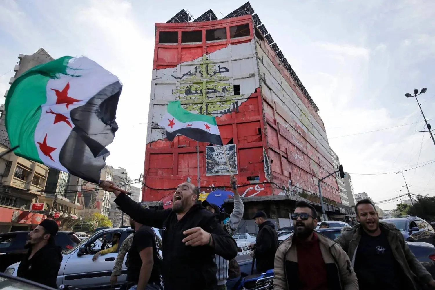 سوريون ولبنانيون يحتفلون بسقوط النظام السوري في مدينة طرابلس شمال لبنان (أرشيفية - أ.ف.ب)