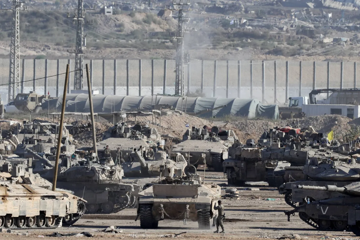 جنود إسرائيليون يقفون بجوار مركبات عسكرية على الحدود مع قطاع غزة يوم 10 أكتوبر 2025 (رويترز)