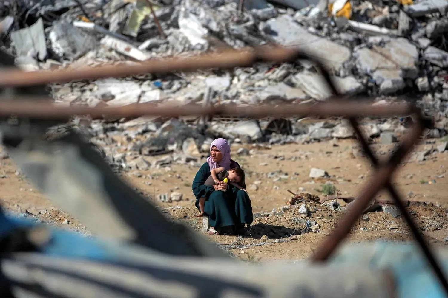 A Palestinian woman holds her child beside piles of rubble while heading toward Gaza City on Friday. (AFP) 