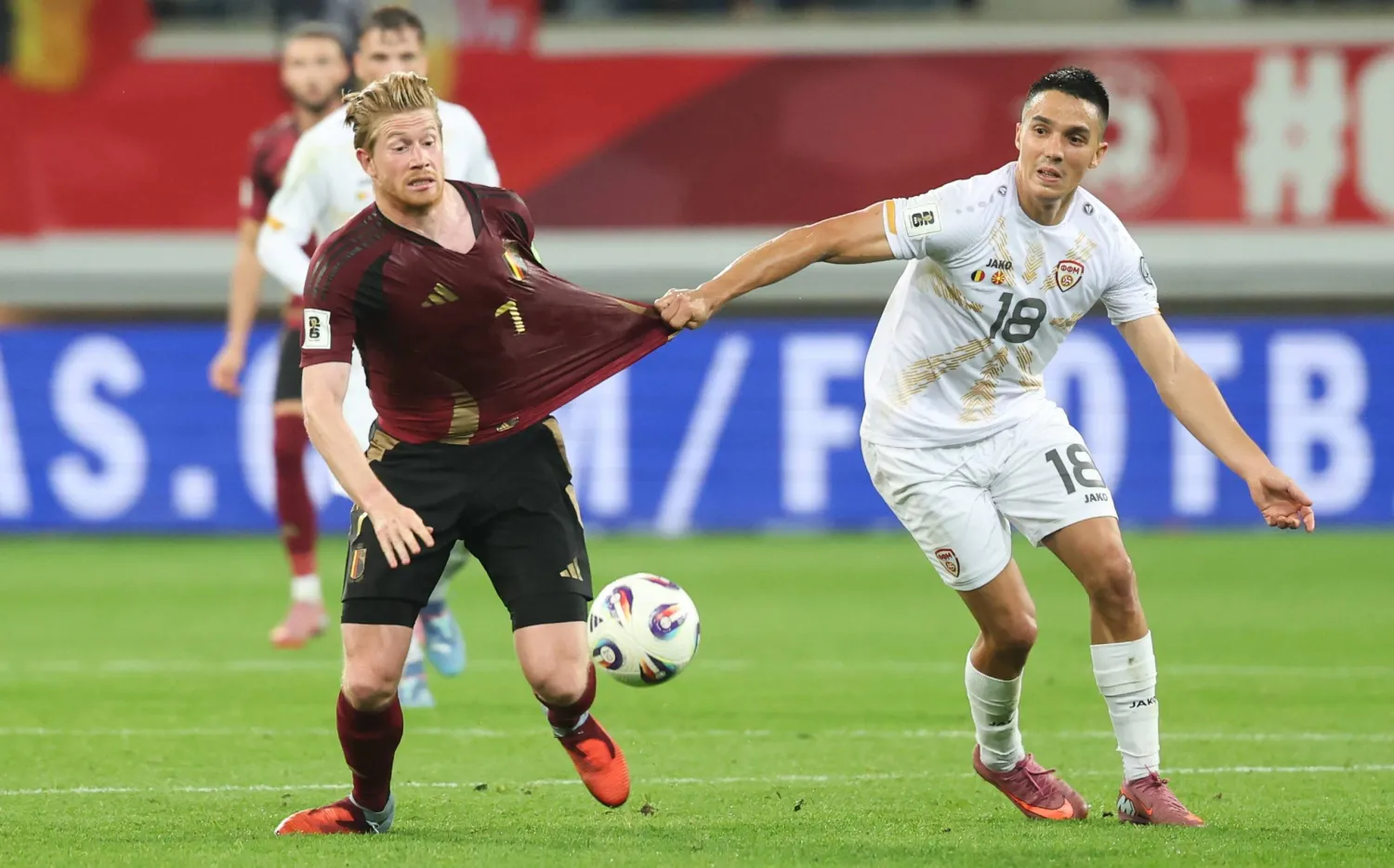 دي بروين يحاول الوصول إلى الكرة وسط مضايقة المقدوني بابونسكي (د.ب.أ)