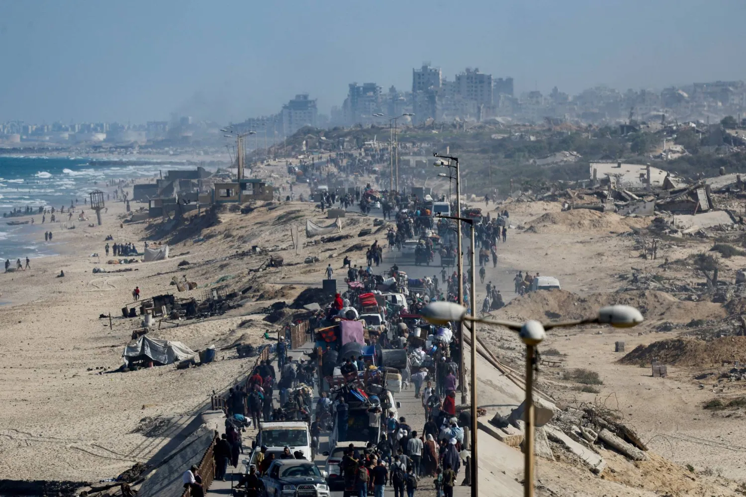 فلسطينيون يشقون طريقهم إلى شمال قطاع غزة مع دخول وقف إطلاق النار حيز التنفيذ (رويترز) 