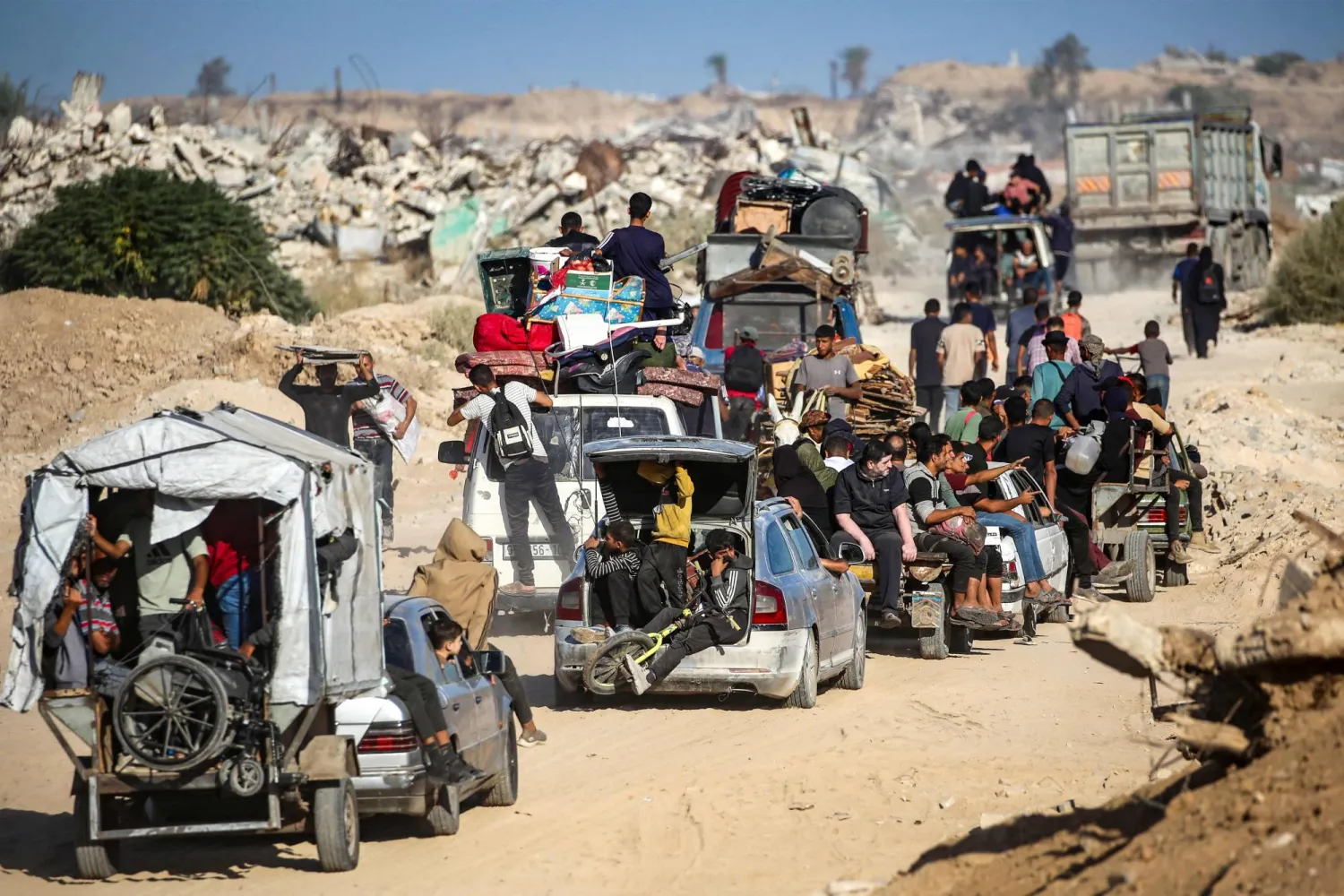 فلسطينيون يجمعون ممتلكاتهم ويعودون إلى مدينة غزة (أ.ف.ب)