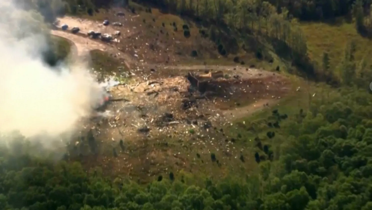 Smoke fills the air as debris covers the ground and vehicles after a powerful blast ripped through a military explosives manufacturing plant in Hickman County, Tenn., on Friday, Oct. 10, 2025. (WTVF-TV via AP)