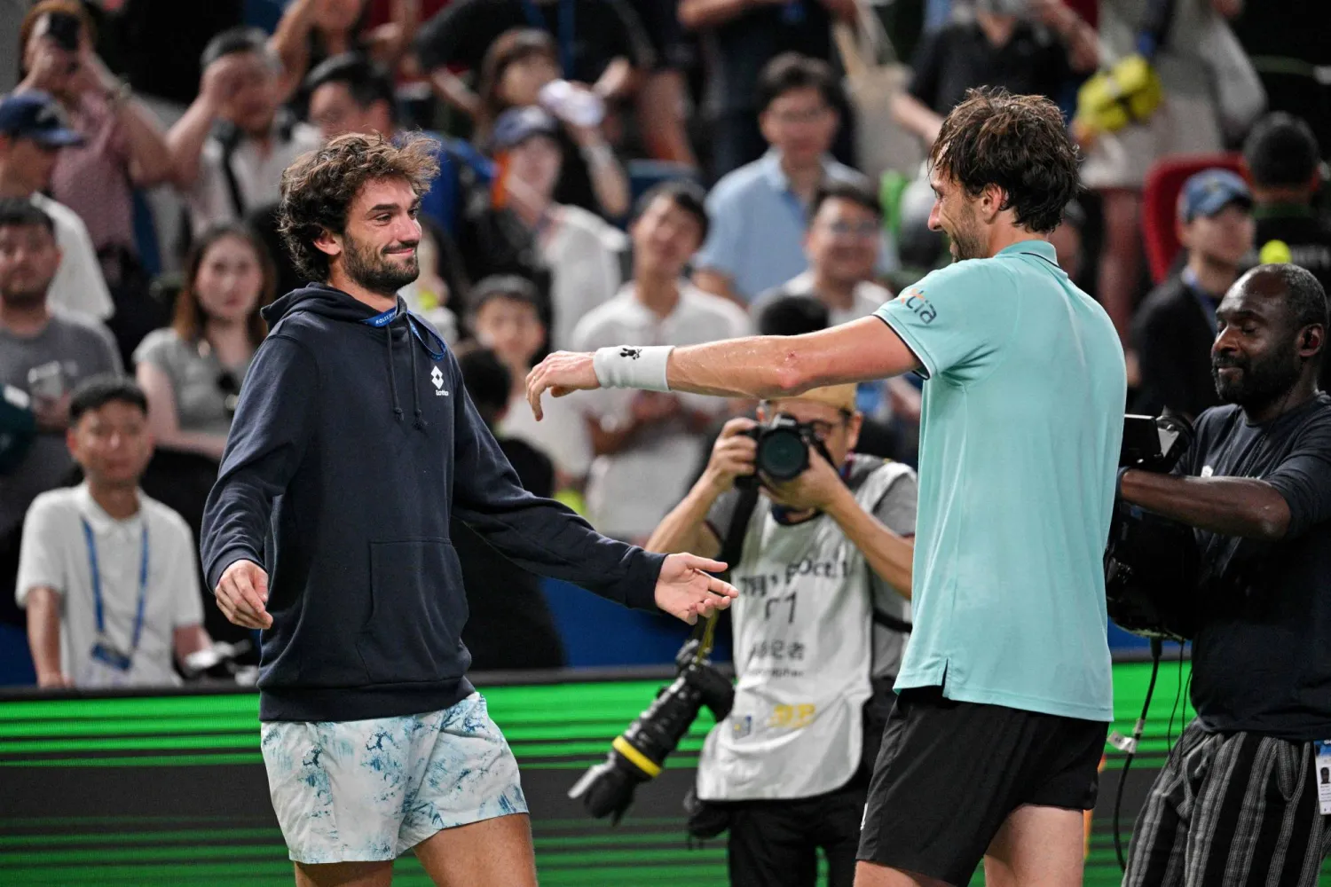 France's Arthur Rinderknech celebrates with Monaco's Valentin Vacherot after winning against Russia's Daniil Medvedev at the end of their men's singles semi-final match during the Shanghai Masters tennis tournament in Shanghai on October 11, 2025. (Photo by Hector RETAMAL / AFP)
