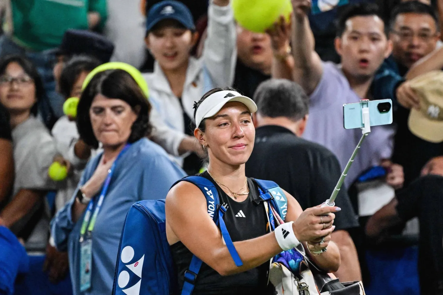 USA’s Jessica Pegula takes a selfie with fans as she celebrates her victory against Belarus’s Aryna Sabalenka at the end of their women’s singles semi-final match during the Wuhan Open tennis tournament in Wuhan, central China’s Hubei province on October 11, 2025. (Photo by Adek BERRY / AFP)