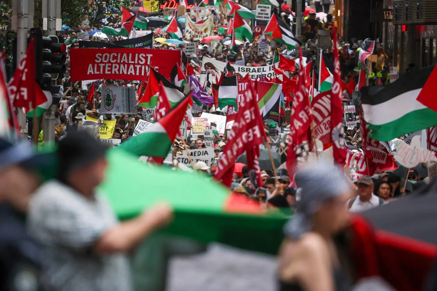 Pro-Palestinian demonstrators hold flags and placards as they march during a Palestinian solidarity rally in Sydney on October 12, 2025, after two years of conflict in Gaza. (Photo by DAVID GRAY / AFP)