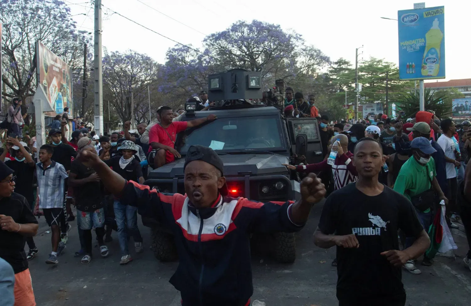 Madagaskar'ın başkenti Antananarivo'da gösteriler sırasında protestocular bir askeri aracın yanından geçiyor (Reuters)