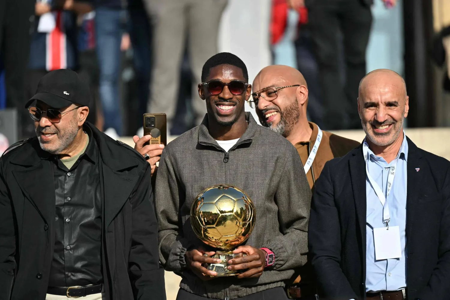 عثمان ديمبلي نجم فريق باريس سان جيرمان الفرنسي يحتفل بالكرة الذهبية في إيفرو (أ.ف.ب)