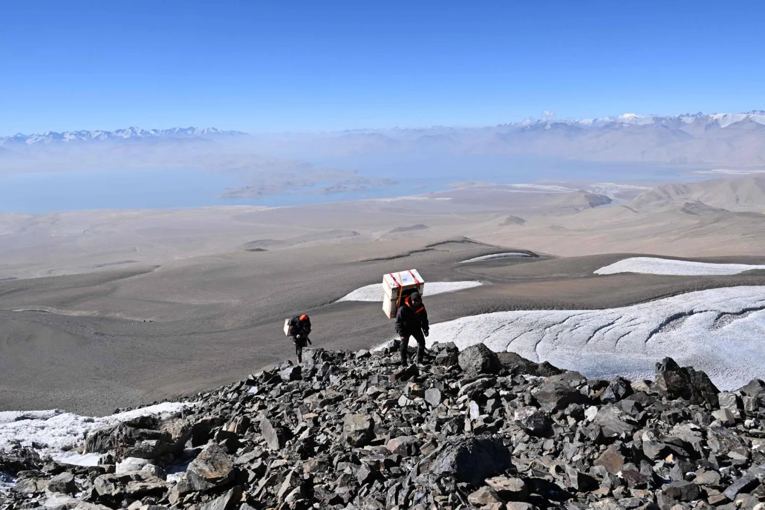 Russia's Ivan Lavrentiev and  Tadjikistan's Jahongir Abdullov, members of the expedition "Pamir-Ice-Memory" climb up at the  base of Pamir Glacier on September 25, 2025 in Kon Chukurbashi, eastern Tadjikistan. (Photo by Prakash MATHEMA / AFP)