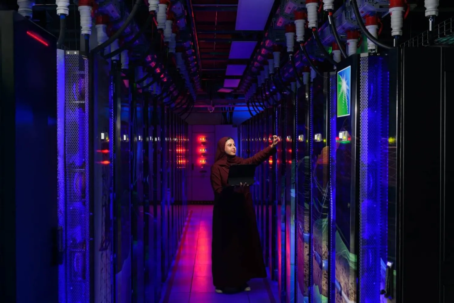 إحدى موظفات «أرامكو» تتوسط أحد الأنظمة الحاسوبية المتقدمة (أرامكو)