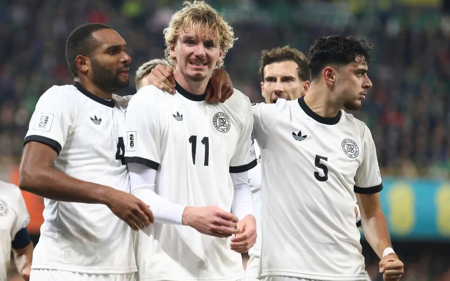 Germany's Nick Woltemade, center, celebrates with teammates Aleksandar Pavlovic, right, and Jonathan Tah, after scoring the opening goal of his team during the World Cup 2026 group A qualifying soccer match between Northern Ireland and Germany at Windsor Park stadium, in Belfast, Northern Ireland, Monday, Oct. 13, 2025. (AP)