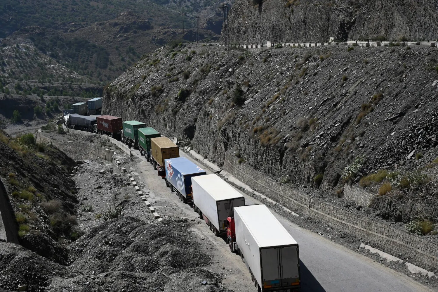 شاحنات محملة بالبضائع متجهة إلى أفغانستان تصطف بانتظار فتح الحدود عقب اشتباكات بين قوات الأمن الباكستانية والأفغانية في تورخام بباكستان يوم 13 أكتوبر 2025... وكانت باكستان أغلقت معبري تورخام وشامان بعد اشتباكات ليلية عنيفة مع القوات الأفغانية (أ.ف.ب)