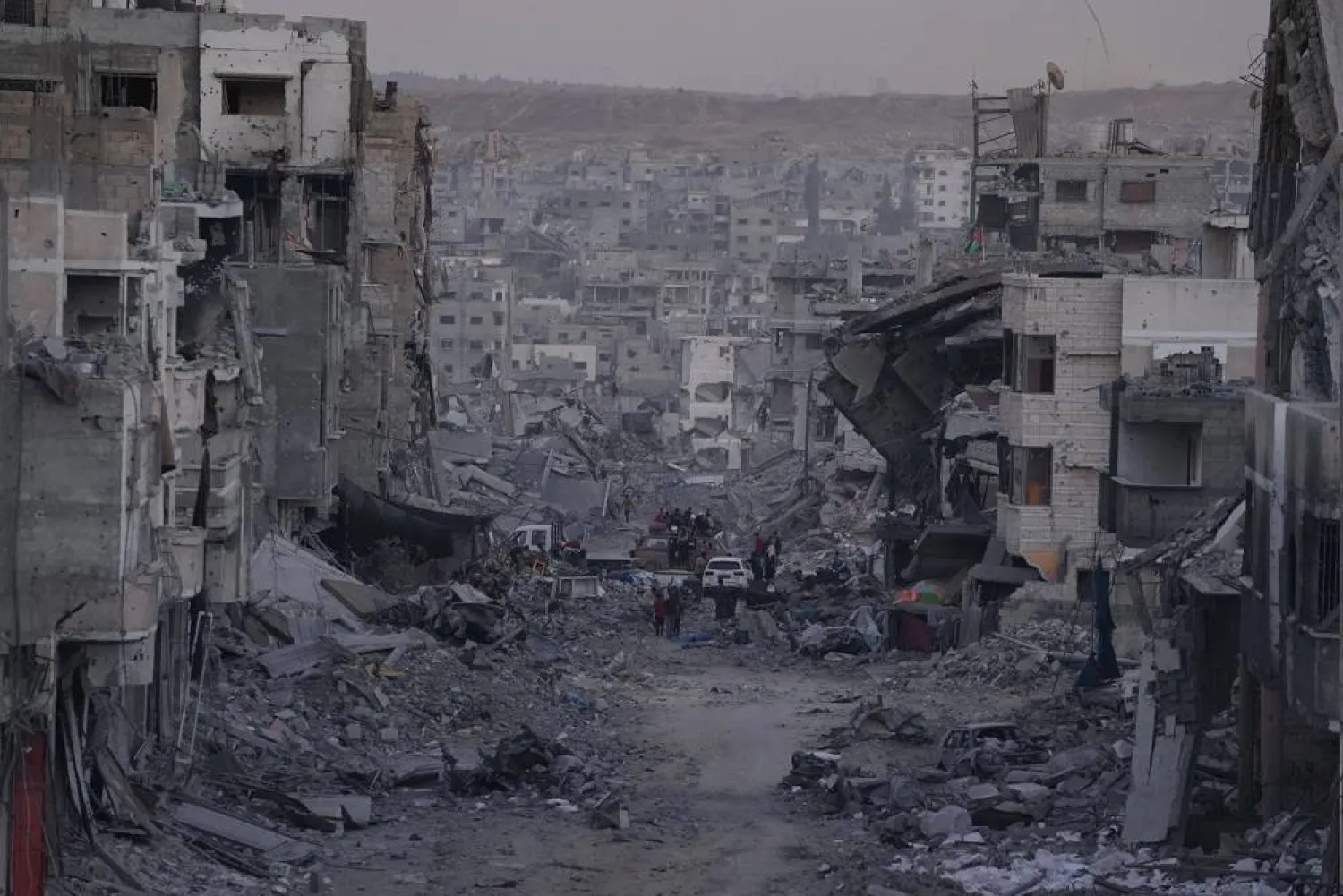Palestinians walk among destroyed buildings in Gaza City, Sunday, Oct. 12, 2025, after Israel and Hamas agreed to a pause in their war and the release of the remaining hostages. (AP)