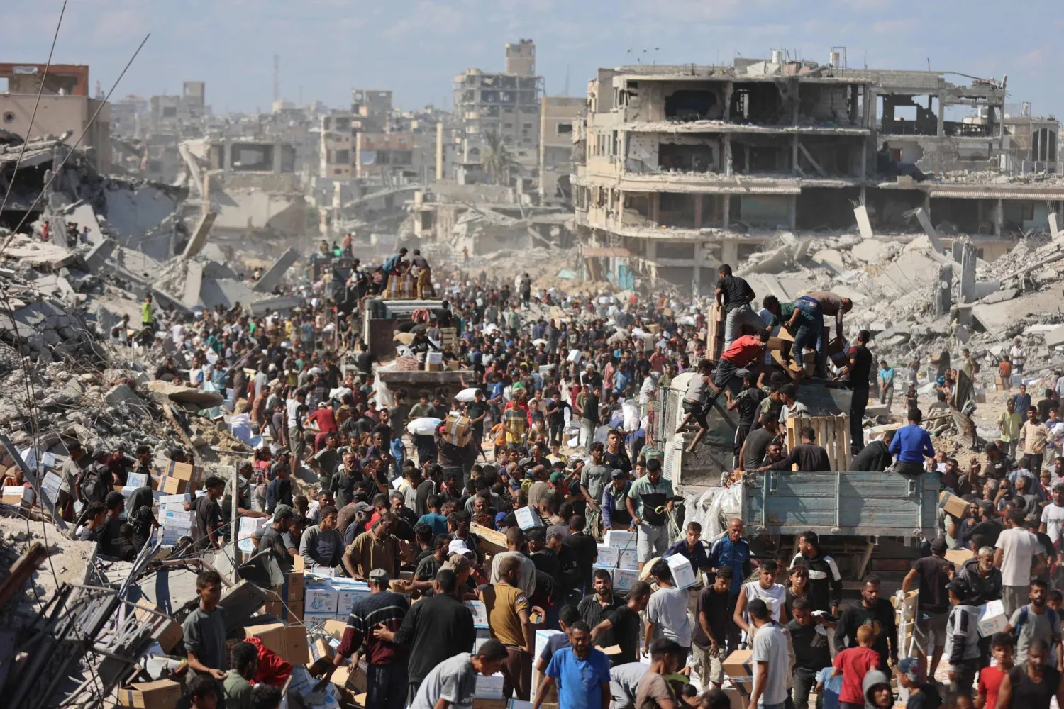 فلسطينيون يحتشدون حول شاحنات مساعدات بعد دخولها إلى قطاع غزة عبر معبر كرم أبو سالم في خان يونس قبل يومين (أ.ف.ب)