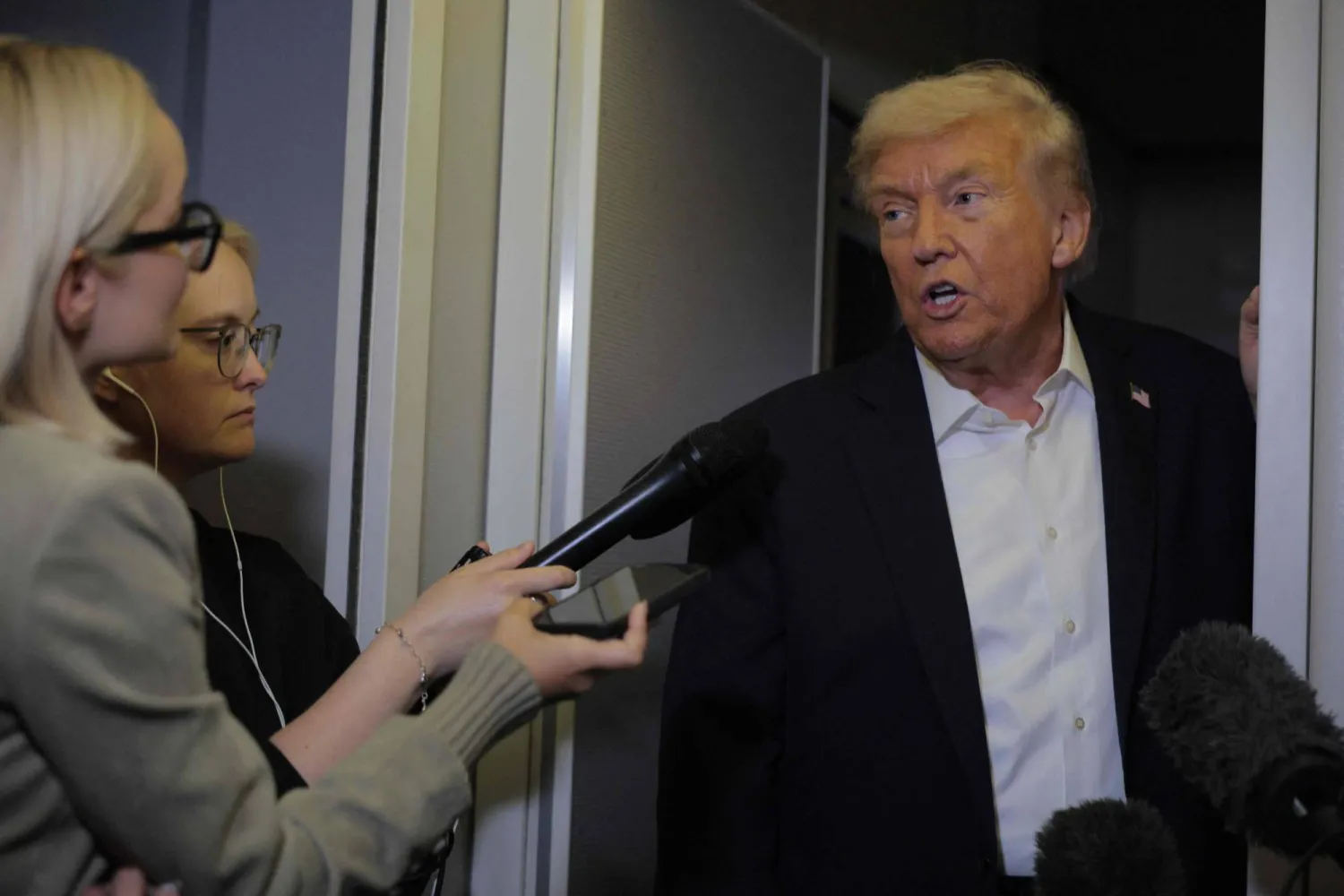 ترمب يتحدث إلى وسائل الإعلام على متن الطائرة الرئاسية (أ.ف.ب)