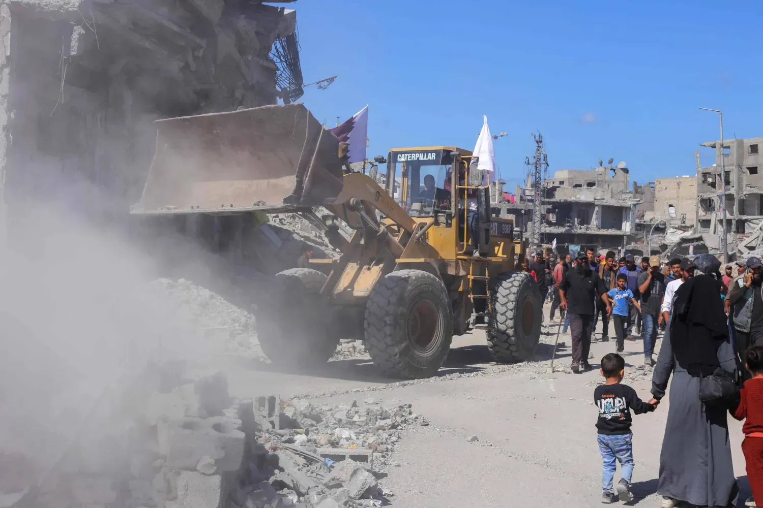 Gazze şehrindeki bir yolun ortasında enkazı temizleyen bir buldozer (AFP)