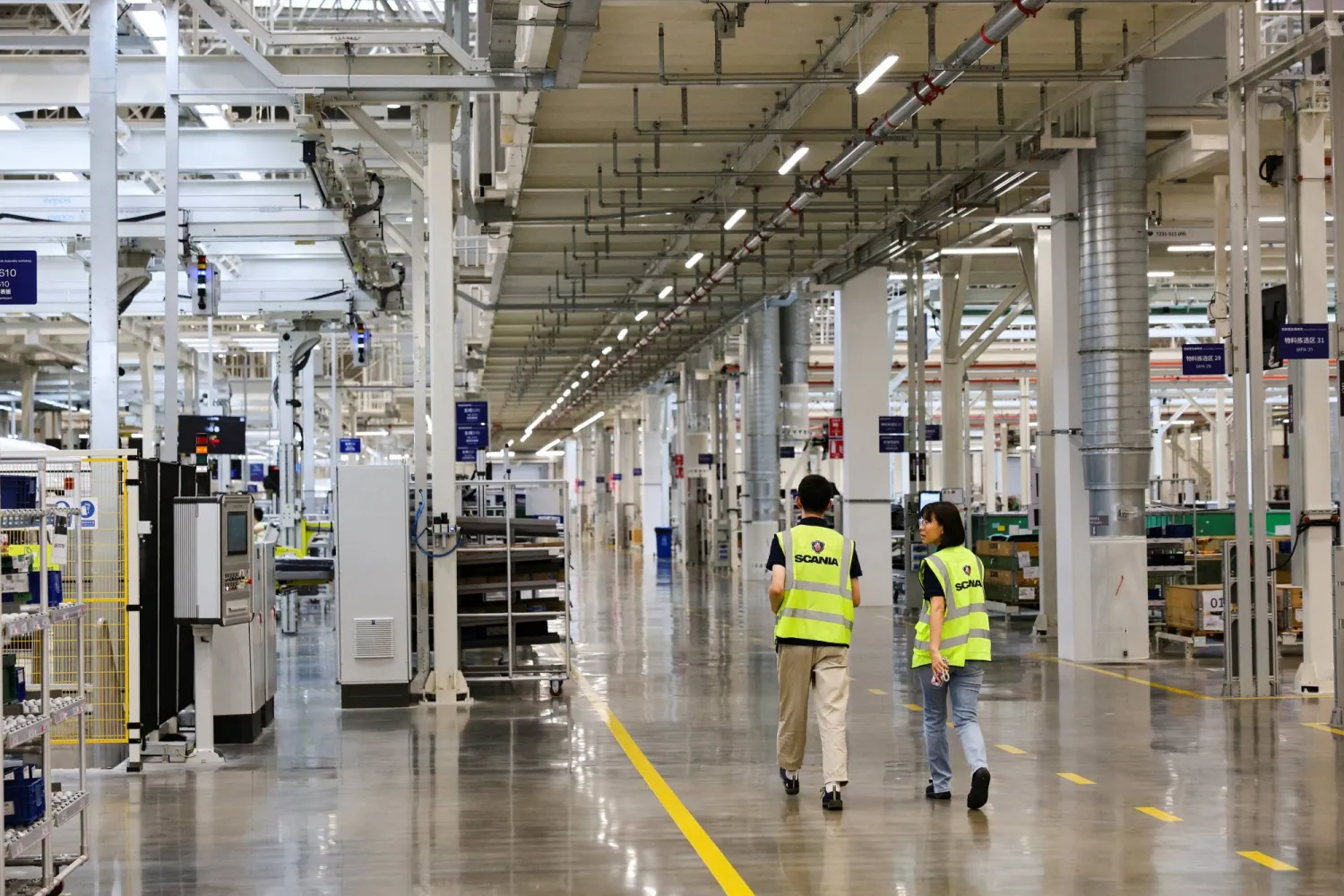 عمال في مصنع «سكانيا» للشاحنات بمدينة روغاو الصينية (رويترز)