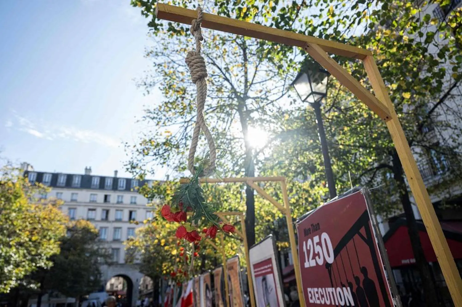 This photograph shows a noose with mock flowers displayed during a demonstration by Franco-Iranian associations, including the Committee to Support Human Rights in Iran (CSDHI) against the capital punishment in Iran, a day after the World Day Against the Death Penalty, in central Paris on October 11, 2025. (AFP)