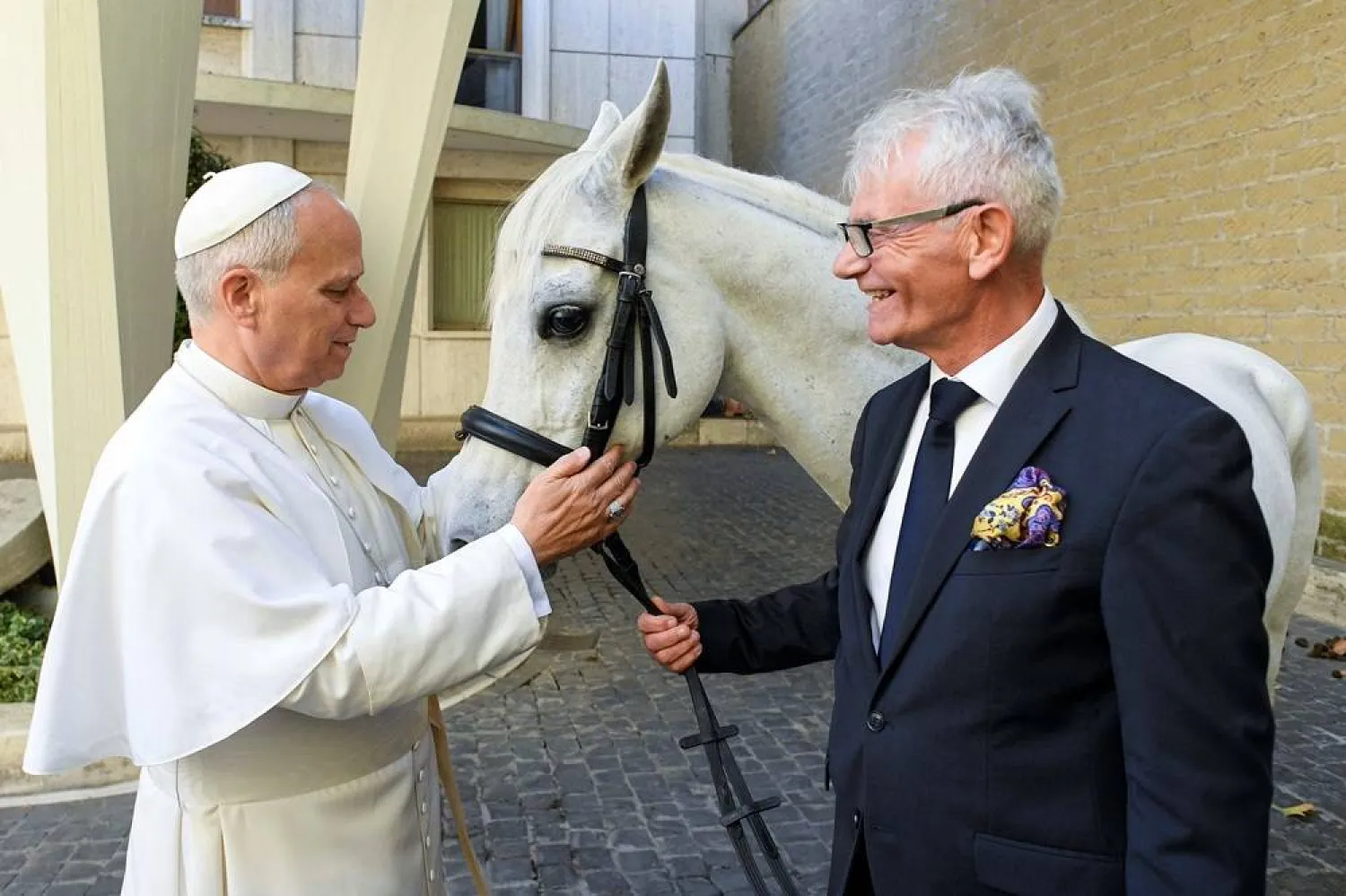 Pope Leo looks at a purebred Arabian horse named "Proton" given as a gift by Andrzej Michalski, owner and founder of the Michalski Stud Farm in Kolobrzeg-Budzistowo, in Poland, at the Vatican October 15, 2025. (Vatican Media/­Handout via Reuters)