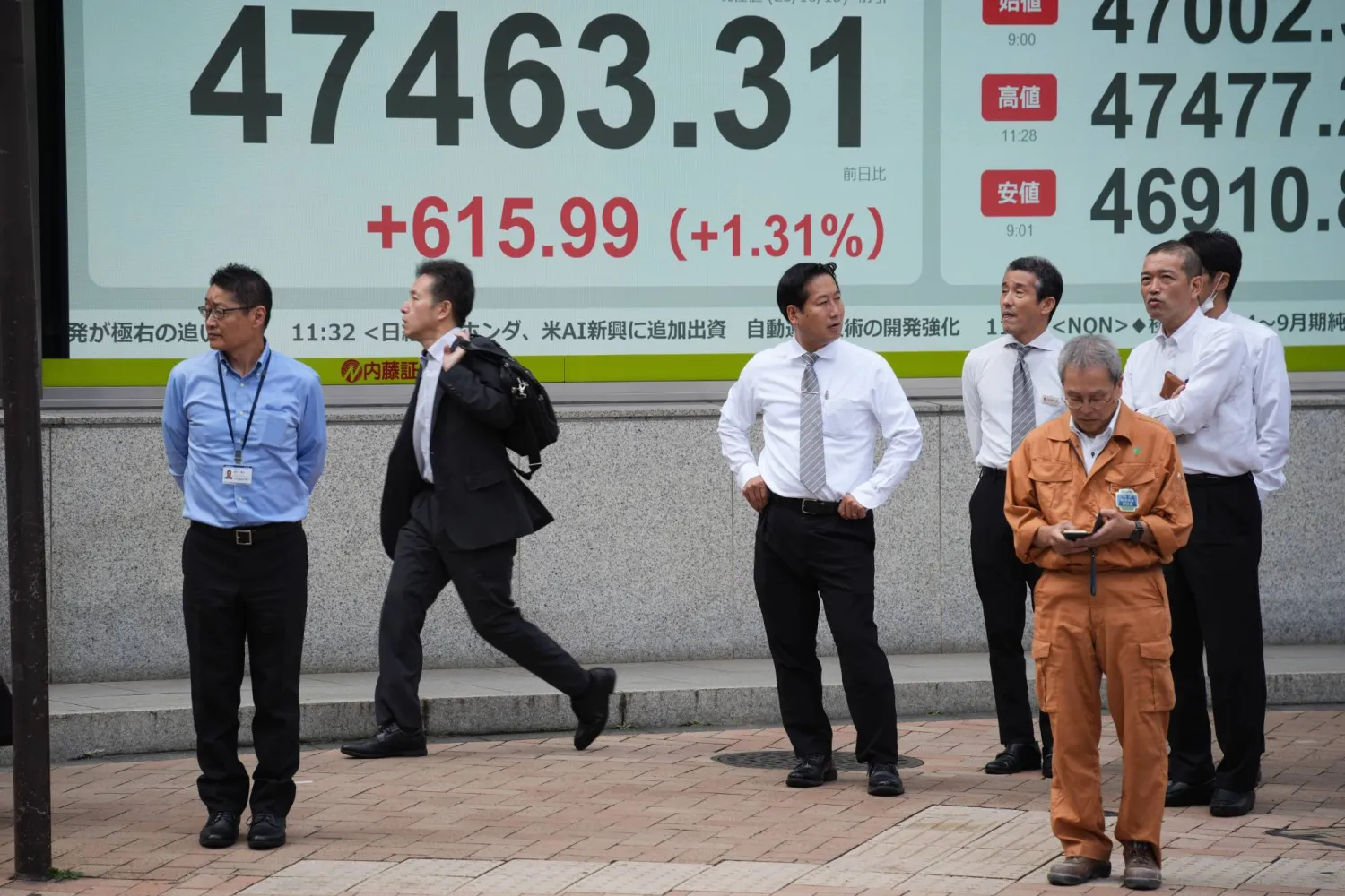 مشاة يمرون أمام شاشة إلكترونية تعرض حركة الأسهم في وسط العاصمة اليابانية طوكيو (أ.ب)