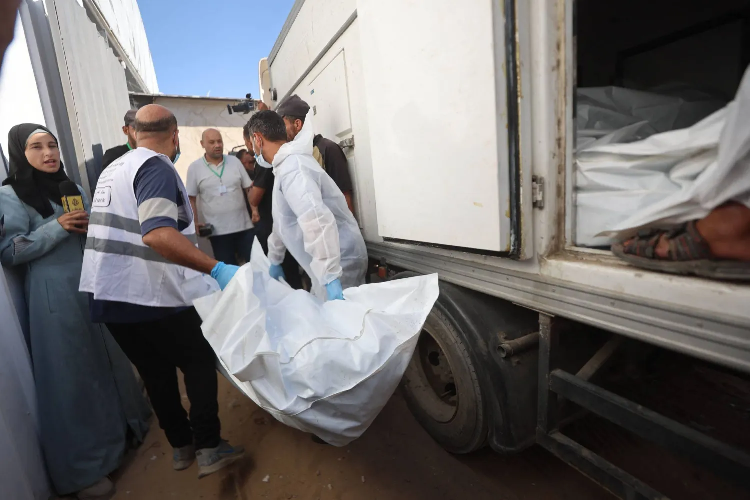 عاملون في المشرحة ينقلون جثامين فلسطينيين كانت محتجزة لدى إسرائيل إلى مستشفى ناصر في خان يونس الأربعاء (أ.ف.ب)