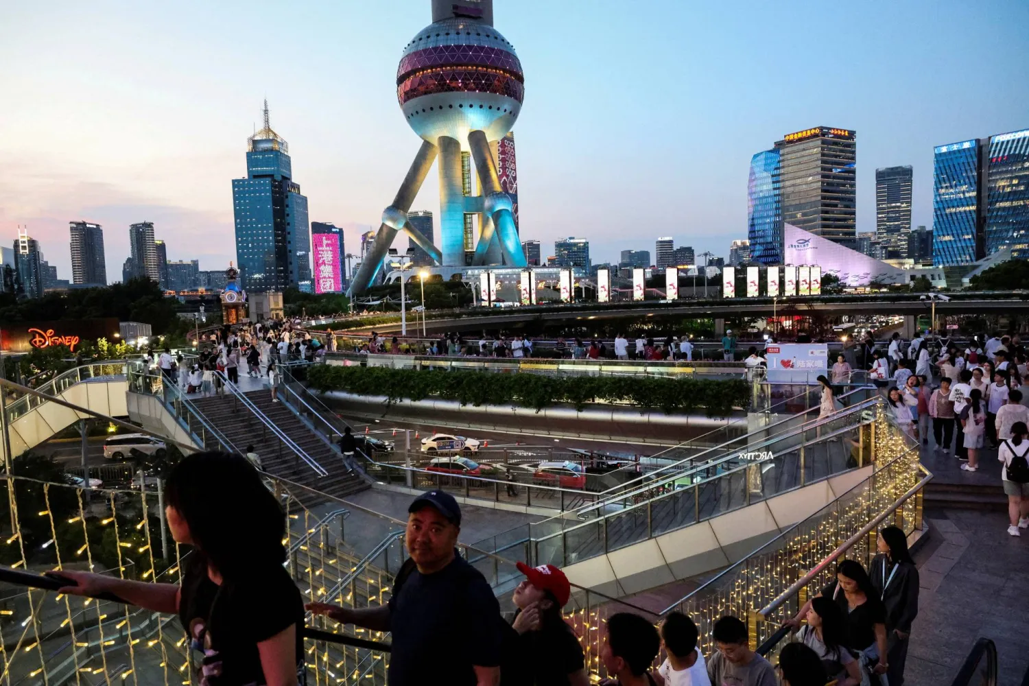 مشاة في الضاحية المالية بمدينة شنغهاي الصينية (رويترز)