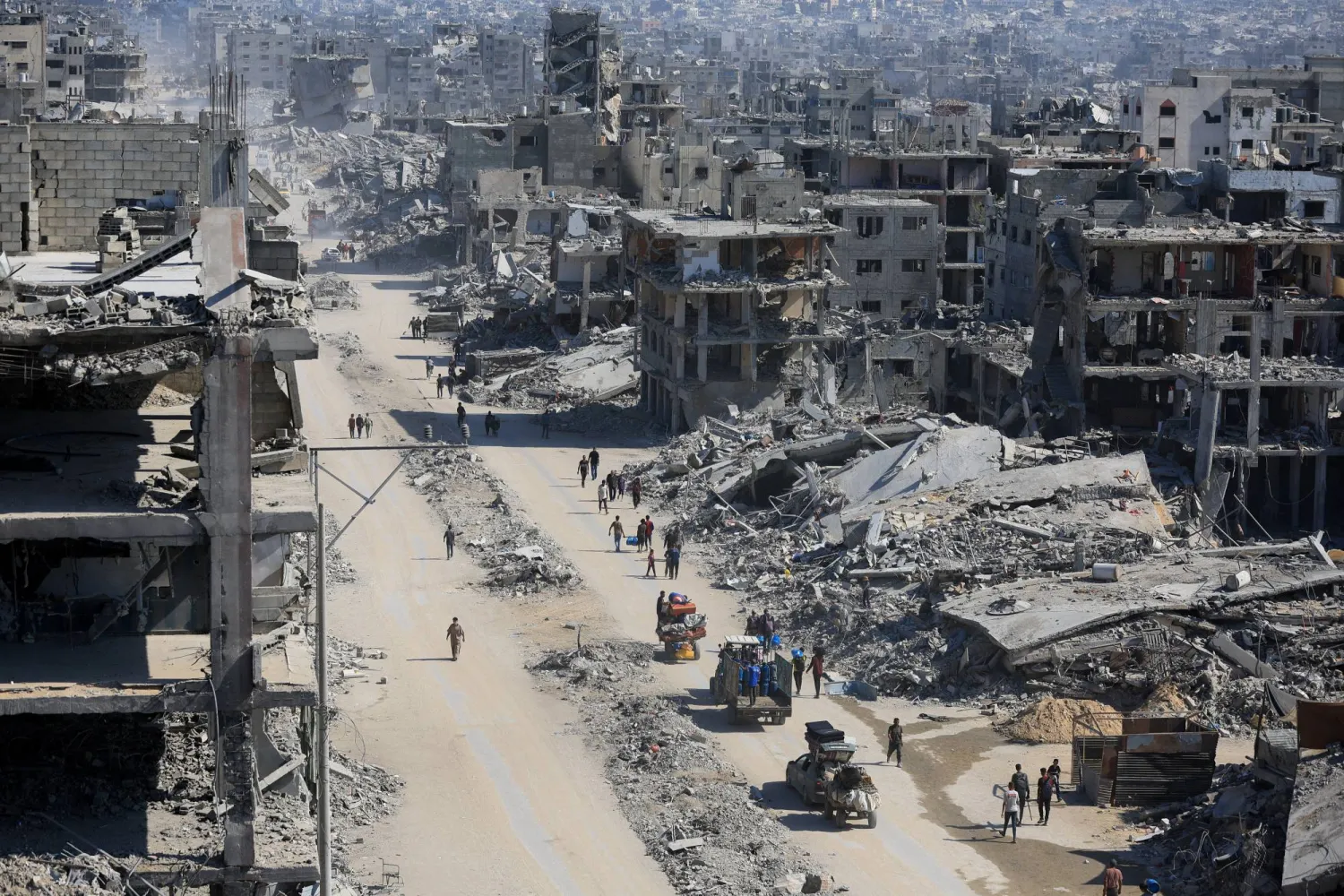 فلسطينيون يسيرون بين أنقاض المباني المدمرة وسط وقف إطلاق النار بين إسرائيل و«حماس» في مدينة غزة 16 أكتوبر 2025 (رويترز)