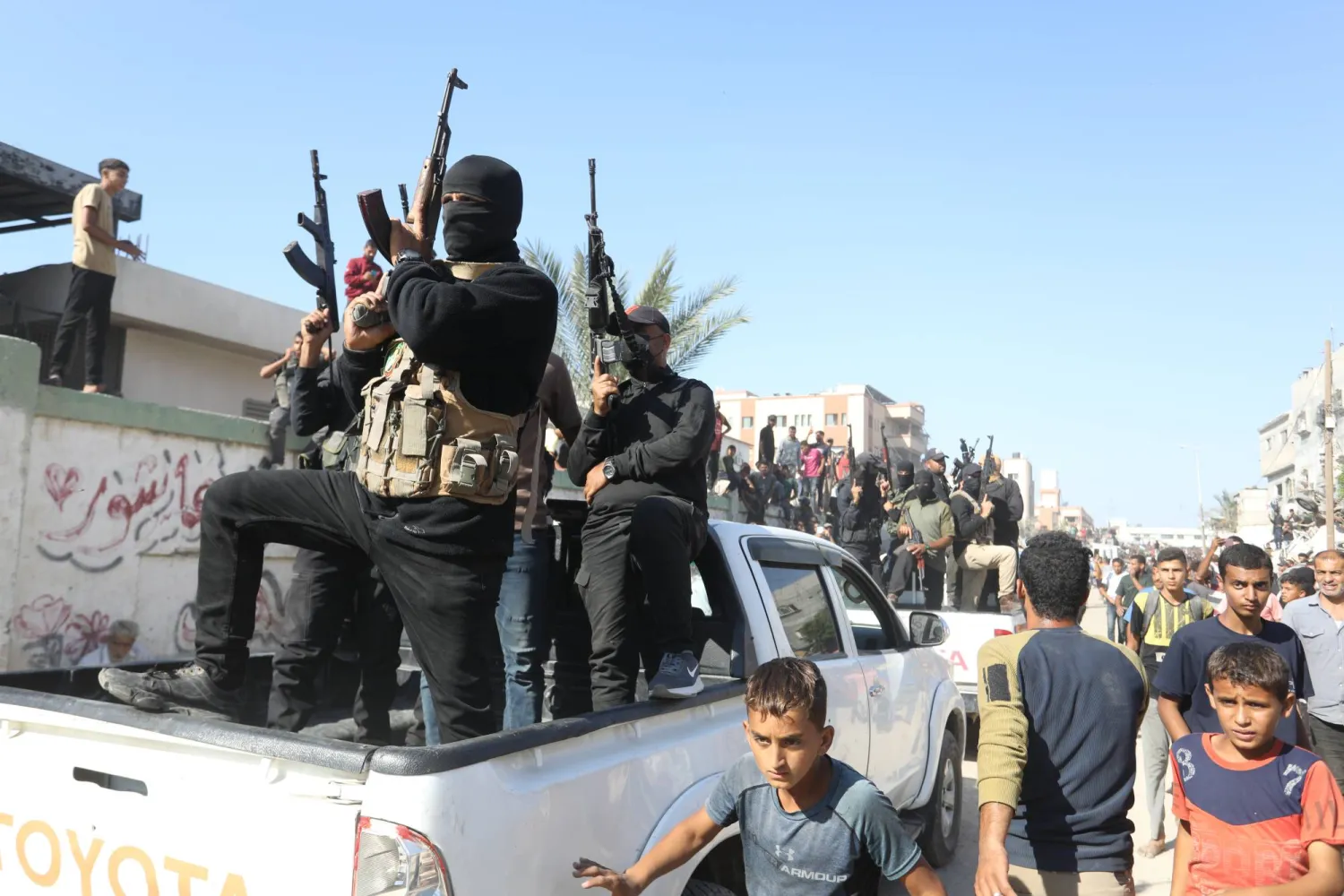 مقاتلون من «حماس» يواكبون حافلات نقلت أسرى فلسطينيين أطلقتهم إسرائيل في خان يونس يوم 13 أكتوبر 2025 (د.ب.أ)