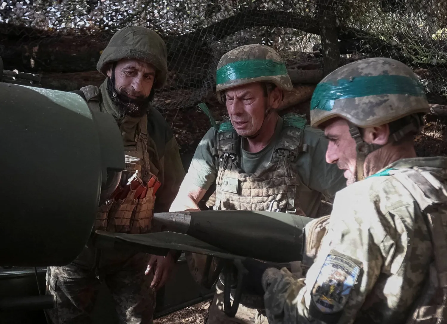 جنود أوكرانيون يحمّلون قذيفة في مدفع هاوتزر ذاتي الحركة في أثناء إطلاقهم النار على القوات الروسية بالقرب من بلدة بوكروفسك على خط المواجهة في منطقة دونيتسك 15 أكتوبر 2025 (رويترز)