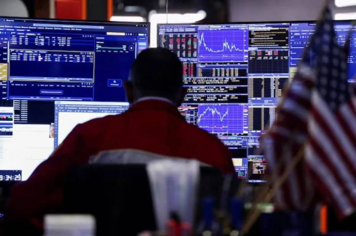 متداول يراقب شاشة الأسهم في قاعة بورصة نيويورك (رويترز)