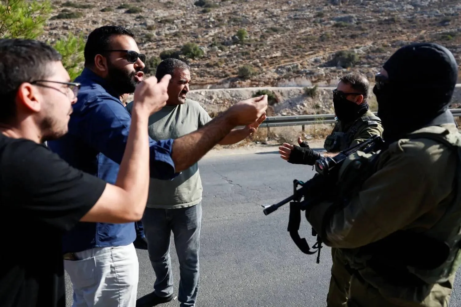 Palestinians protest in front of Israeli soldiers against a road expansion project connecting Israeli settlements to the West Bank (Reuters). 