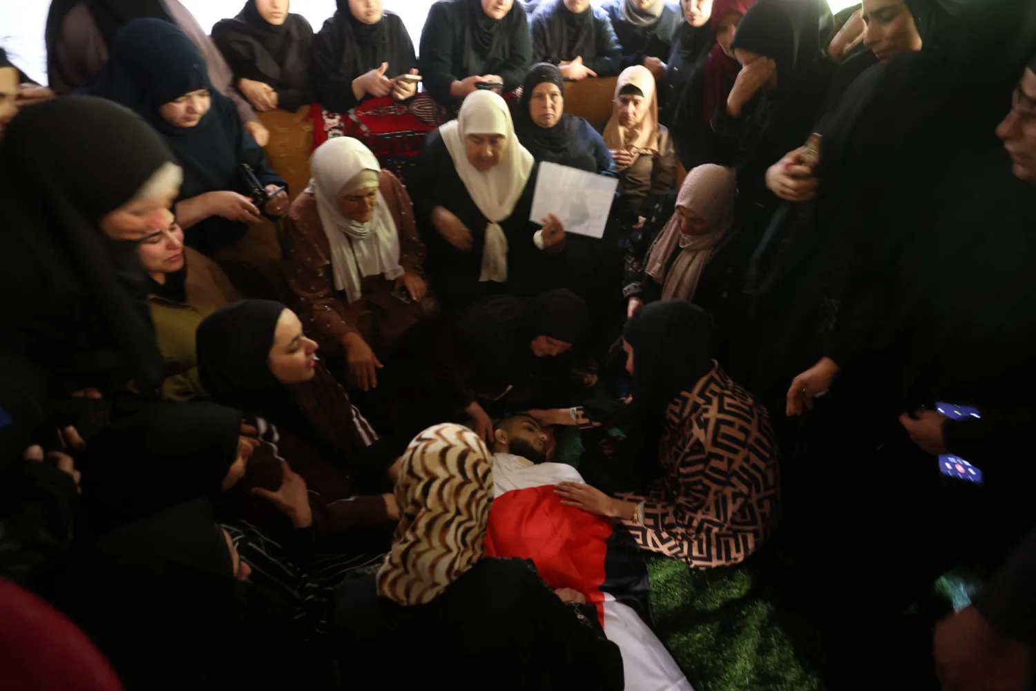 أقارب شاب فلسطيني قتلته القوات الإسرائيلية يبكون خلال جنازته بقرية قباطية جنوب مدينة جنين بالضفة الغربية (إ.ب.أ)