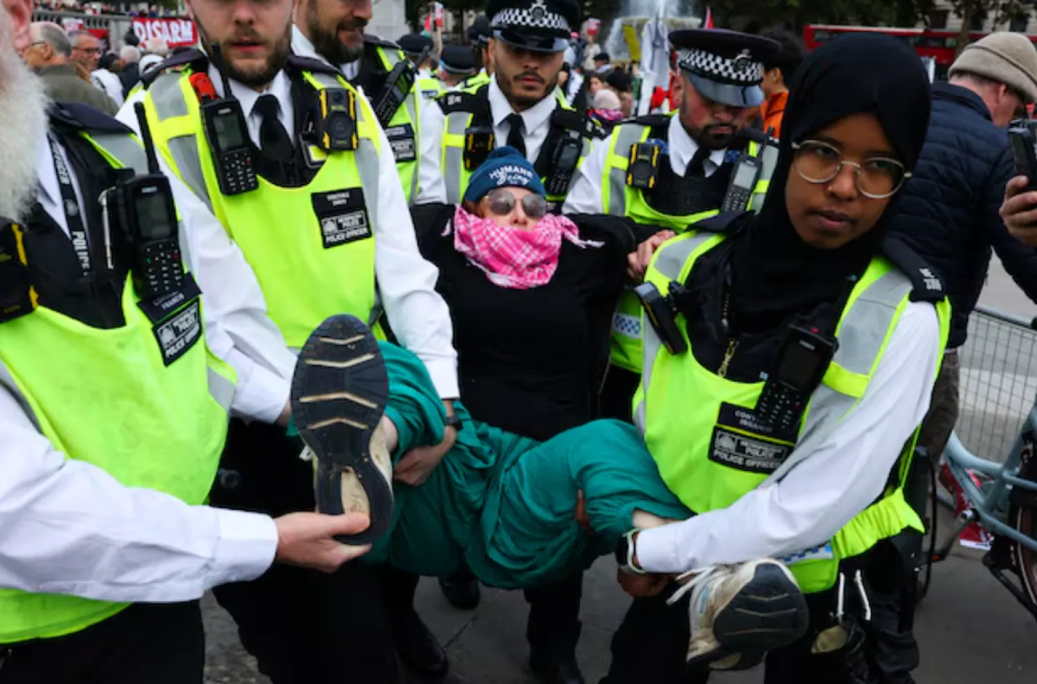 Police officers detain a protester during a mass demonstration organised by Defend our Juries, against the British government's ban on Palestine Action, at Trafalgar Square in London, Britain, October 4, 2025. REUTERS/Toby Melville 