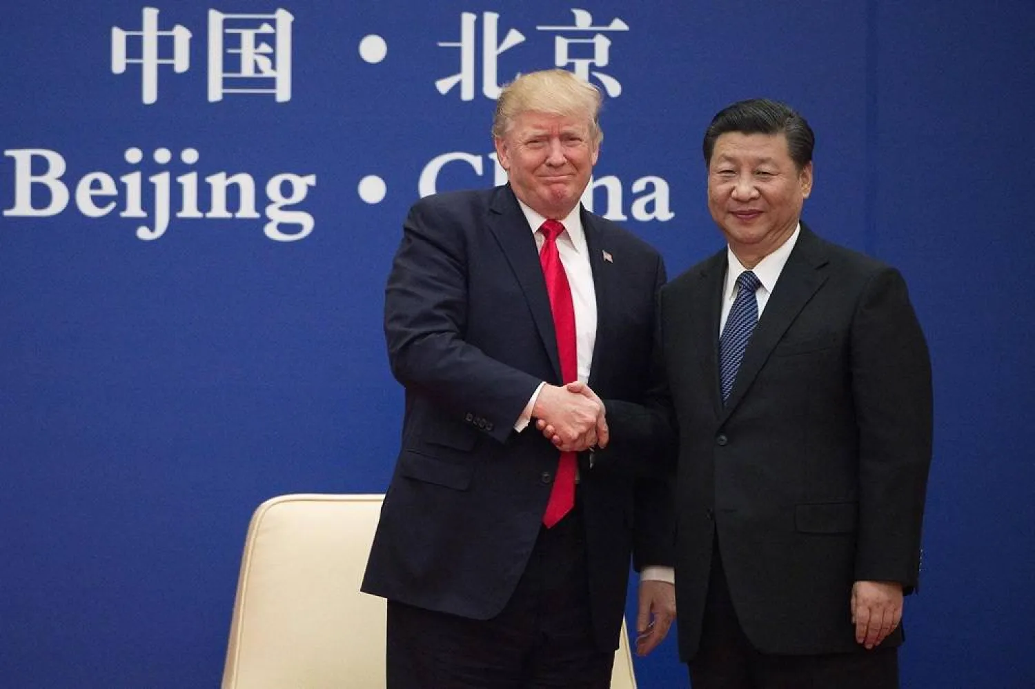 US President Donald Trump (L) and China's President Xi Jinping shake hands during a business leaders event at the Great Hall of the People in Beijing on November 9, 2017. (AFP)