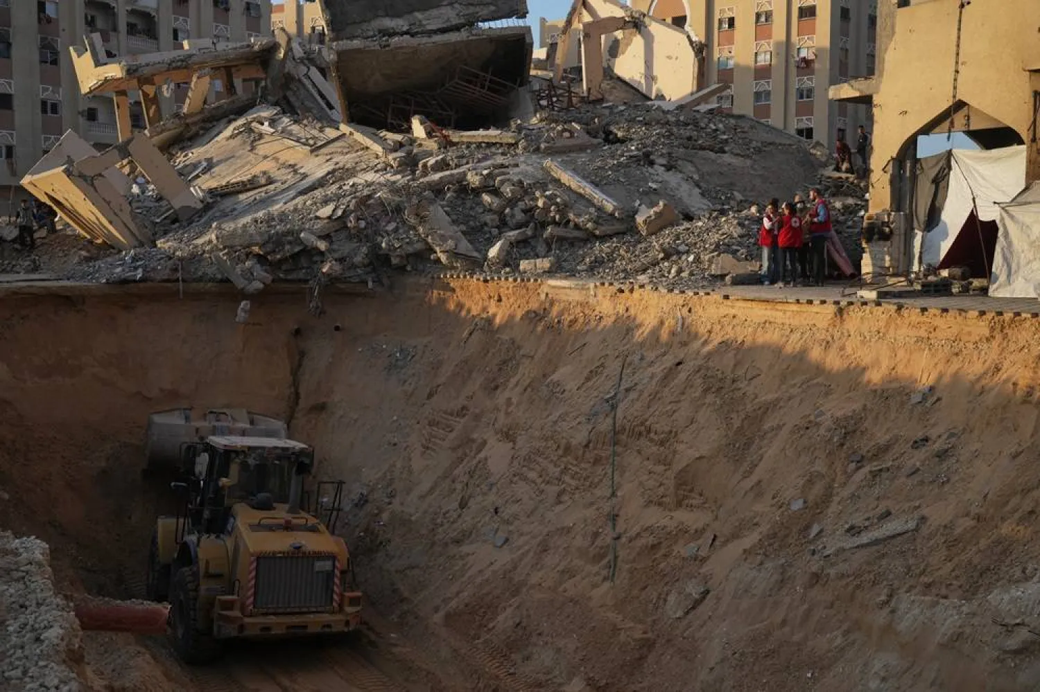 Red Cross workers check the site where members of the Hamas militant group work on searching for bodies of the hostages in an area in Hamad City, Khan Younis, in the southern Gaza Strip, Friday, Oct. 17, 2025. (AP)