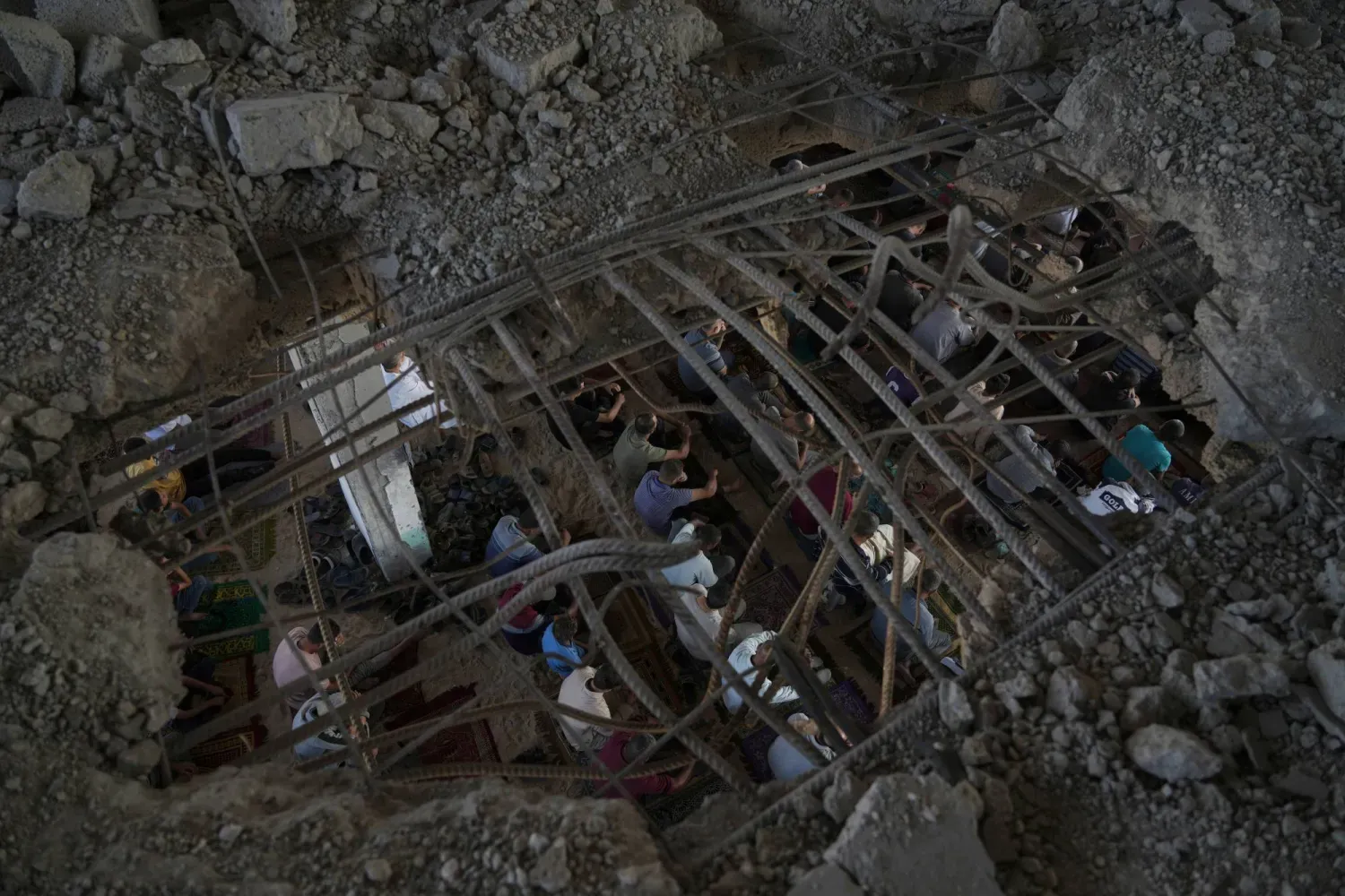 Filistinliler Han Yunus'ta yıkılan bir binanın enkazı arasında (AP)