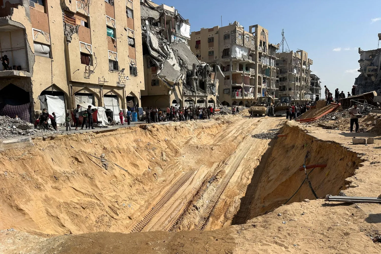 فلسطينيون يعاينون أعمال حفر بحثا عن جثث رهائن إسرائيليين في خان يونس جنوب قطاع غزة أمس (رويترز)
