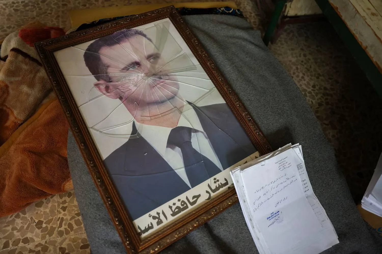 A portrait of ousted Syrian President Bashar al-Assad is pictured with its frame broken, in a Syrian regime's Political Security Branch facility on the outskirts of the central city of Hama, following the capture of the area by anti-government forces, on December 7, 2024. (AFP via Getty Images) 