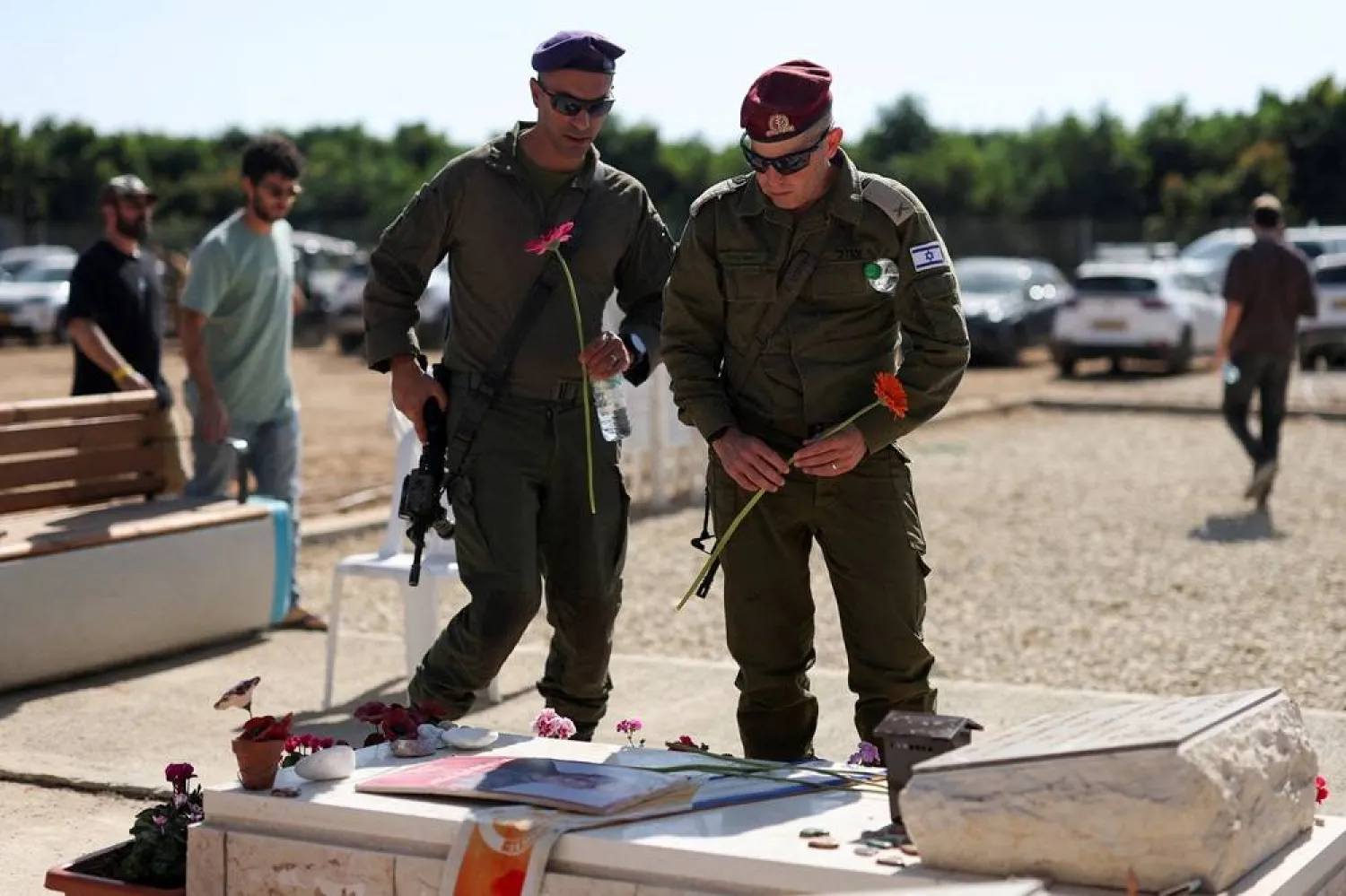  Israeli soldiers hold flowers as the community of Kibbutz Kfar Aza commemorates their members who were killed, taken hostage and who died in captivity, following the deadly October 7, 2023 attack by Hamas, in Kibbutz Kfar Aza, southern Israel, October 16, 2025. (Reuters)