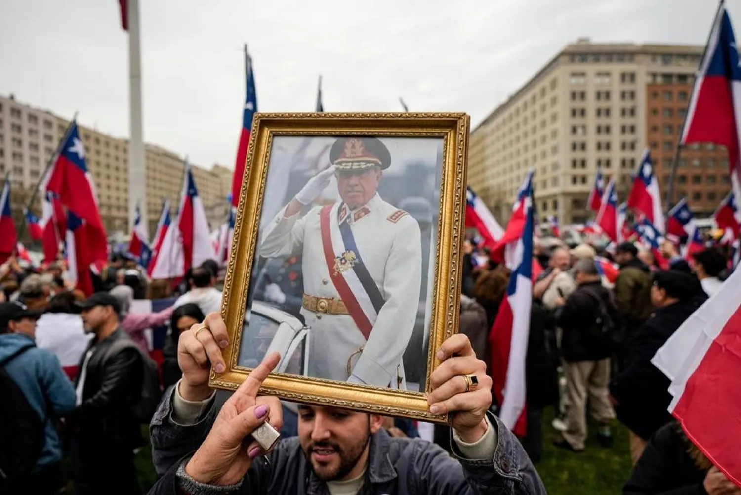 A group in favor of Gen. Augusto Pinochet celebrate the 50th anniversary of a military coup led by Pinochet, near La Moneda presidential palace, in Santiago, Chile, Sept. 9, 2023. (AP) 