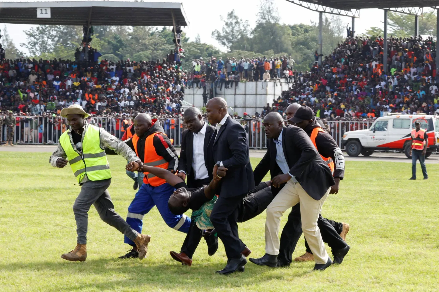 أشخاص ينقلون أحد المعزين المصابين خلال مراسم جنازة زعيم المعارضة الكينية رايلا أودينغا (رويترز)