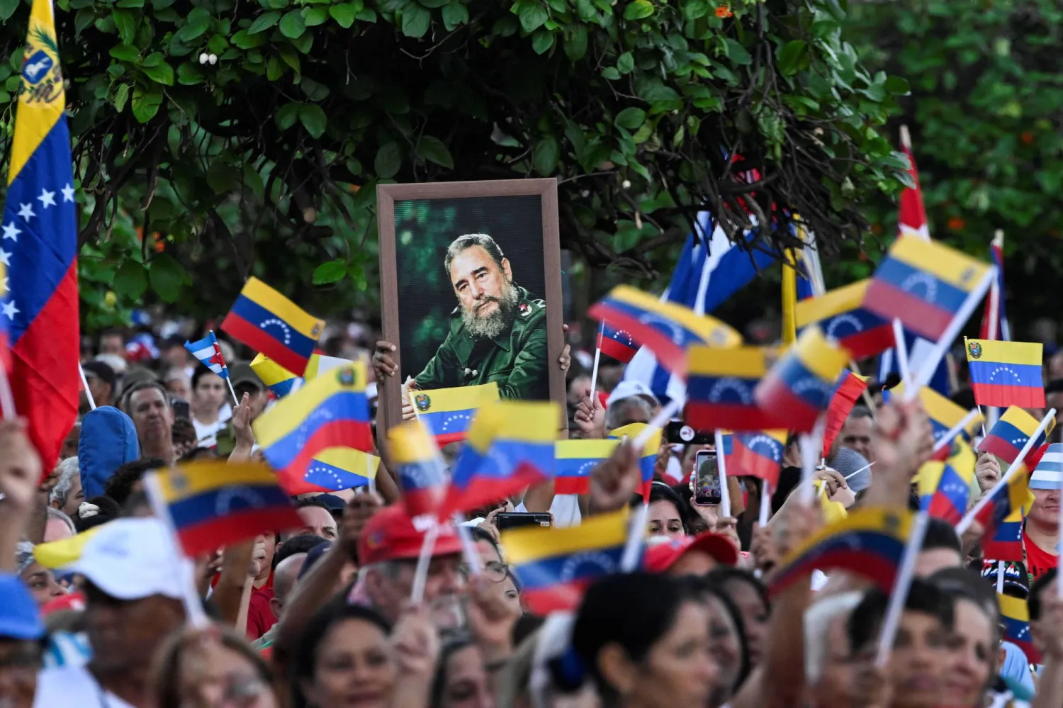 متظاهرون يحملون في هافانا صور فيدل كاسترو وأعلاماً فنزويلية تضامناً مع هذا البلد عقب الحشد العسكري الأميركي يوم 17 أكتوبر (رويترز)