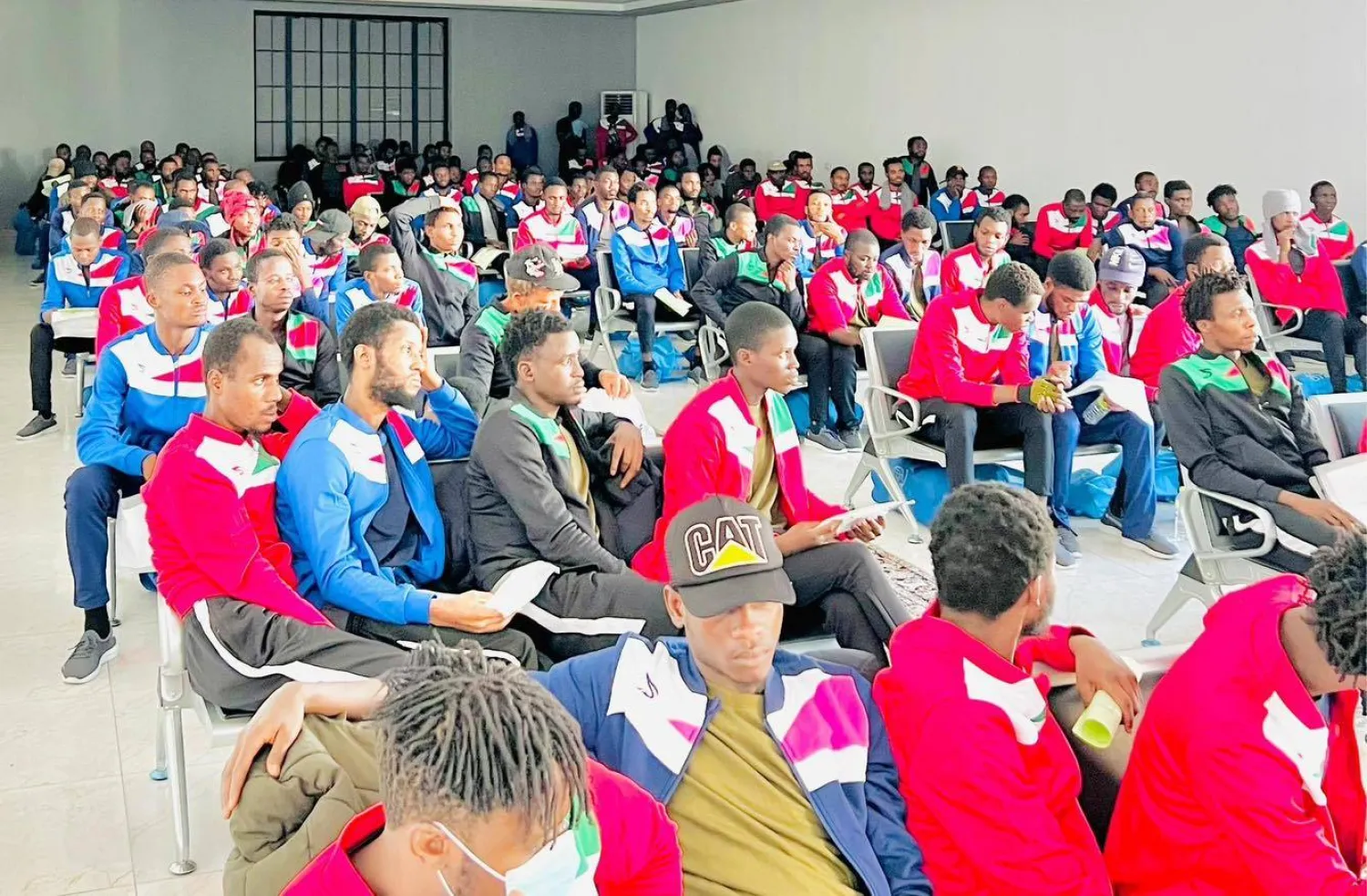 مهاجرون غير نظاميين ينتظرون الترحيل في مطار معيتيقة بالعاصمة الليبية (جهاز مكافحة الهجرة غير الشرعية)