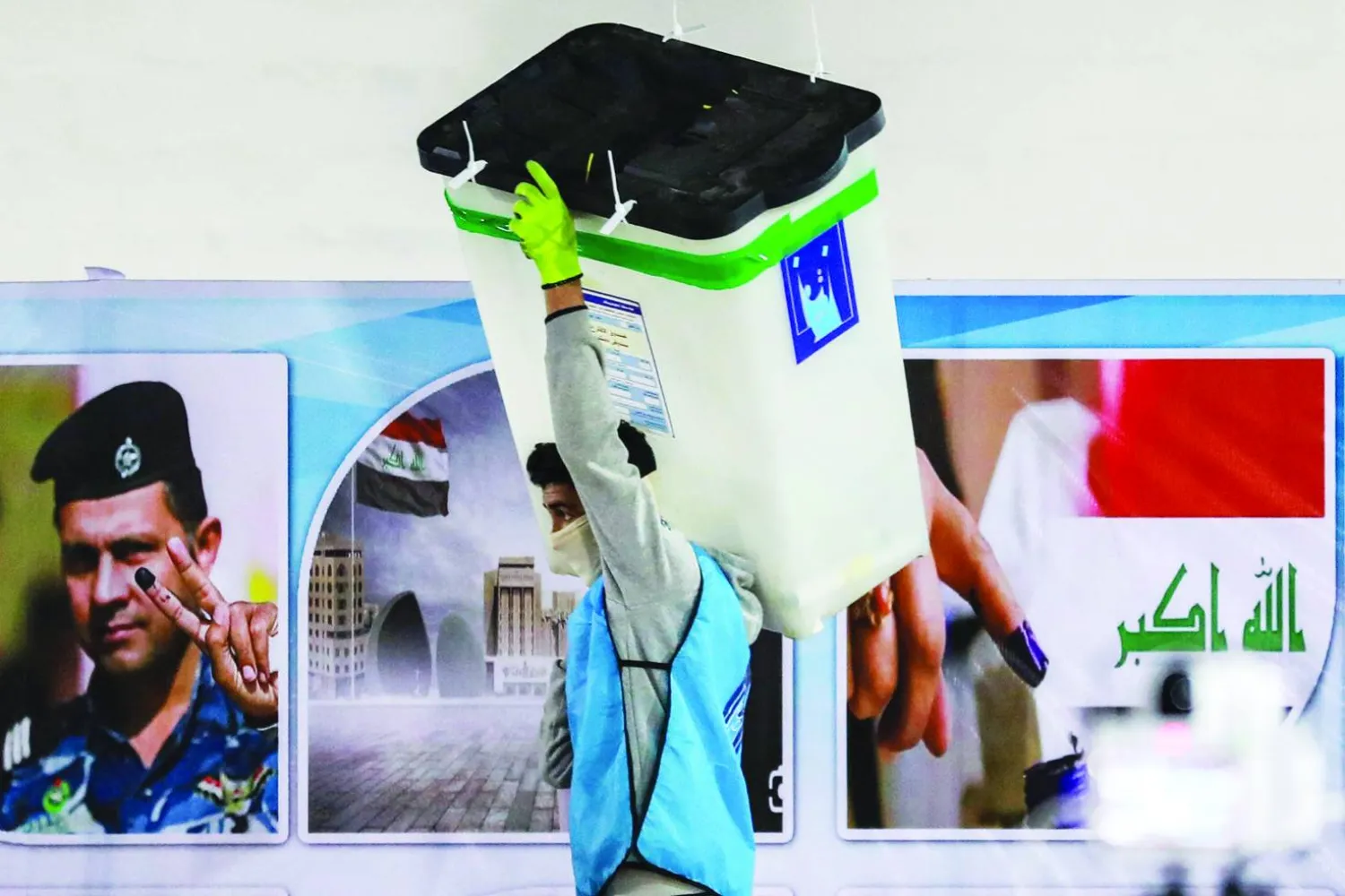 موظف في «هيئة الانتخابات» العراقية يحمل صندوقاً بمركز لفرز الأصوات المحلية في ديسمبر 2023 (أ.ف.ب)