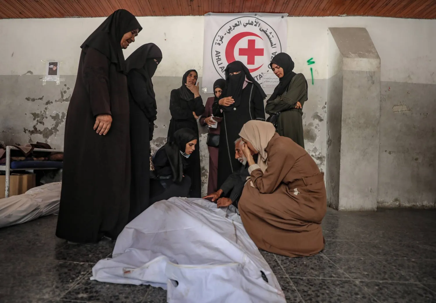 فلسطينيات يبكين أحد قتلى عائلة أبو شعبان الذين استهدفتهم غارة إسرائيلية في مستشفى المعمداني بمدينة غزة السبت (إ.ب.أ)