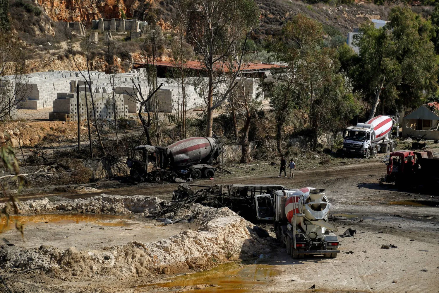 17 October 2025, Lebanon, Ansar: People walk past destruction at the site of quarry and cement factory in the southern Lebanese village of Ansar that was shattered by Israeli air strikes. (dpa)