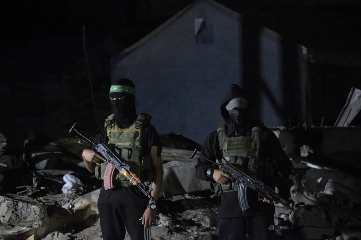 مقاتلون من «كتائب القسام» يحرسون مركبات للصليب الأحمر وصلت لنقل جثث رهائن إسرائيليين بمدينة غزة الأربعاء الماضي (إ. ب.أ)