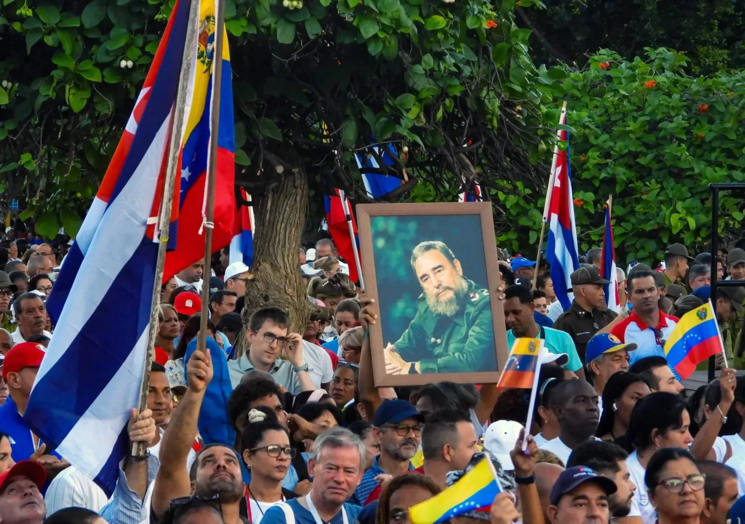 Havana'da 17 Ekim'de ABD'nin askeri güçlerini artırmasının ardından ülkeye destek olmak için Fidel Castro'nun fotoğrafları ve Venezuela bayrakları taşıyan protestocular (AFP)